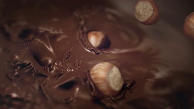 榛子掉进液体巧克力4K超级慢动作视频素材