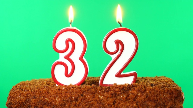 蛋糕和32号点燃的蜡烛。色度键。绿色的屏幕。孤立的视频下载