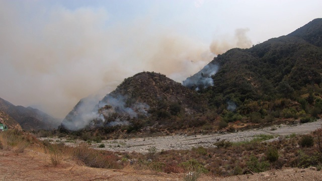 加州大火的4K视频，天空起重机和贝尔直升机往火中洒水视频素材