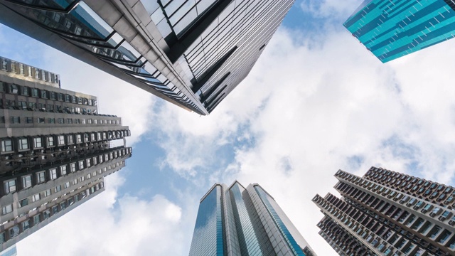 时间推移:垂直的高层摩天大楼在香港城市景观与云移动的背景视频素材