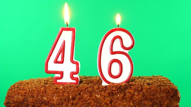 蛋糕上有点燃的46号蜡烛。色度键。绿色的屏幕。孤立的视频下载