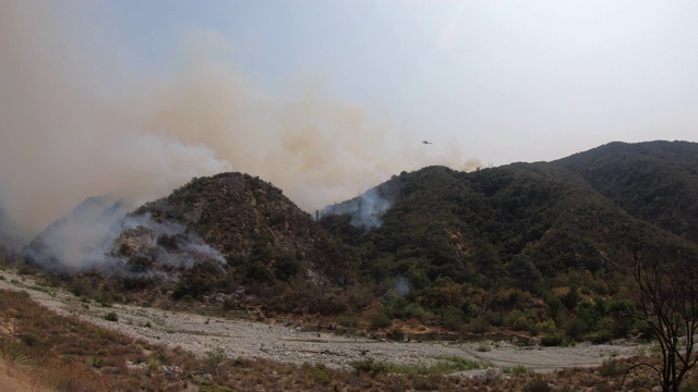 加州大火的4K视频，天空起重机和贝尔直升机往火中洒水视频素材