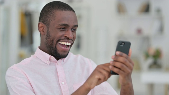 非洲人在智能手机上庆祝成功的肖像视频素材