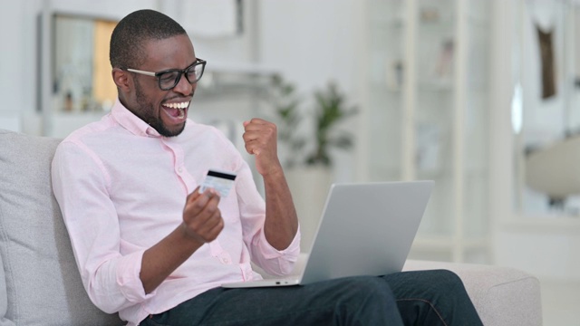 非洲男子在家中笔记本电脑上成功在线支付视频素材