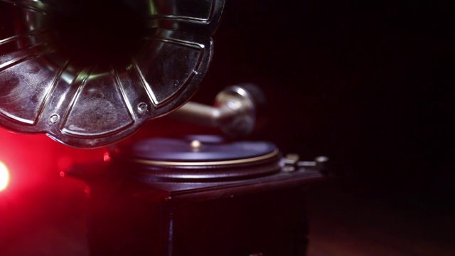 音乐的概念。黑色背景上的老式留声机。木桌上的复古留声机，带有柔和的背光。滑块拍摄视频素材