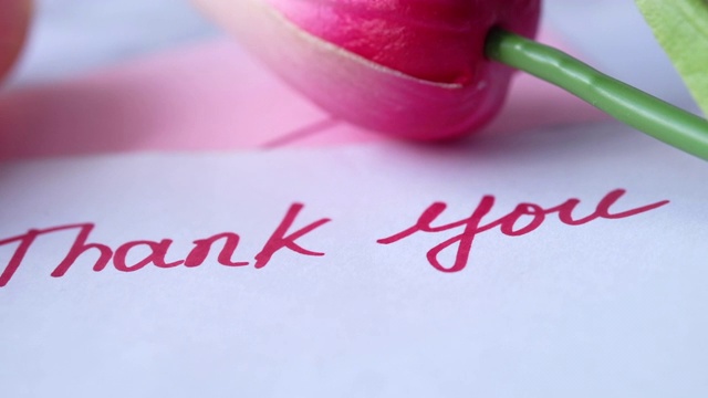 在粉色背景上印有郁金香花的便利贴上留言表示感谢视频下载