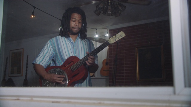 一名非裔美国人在家中弹奏共鸣吉他视频素材