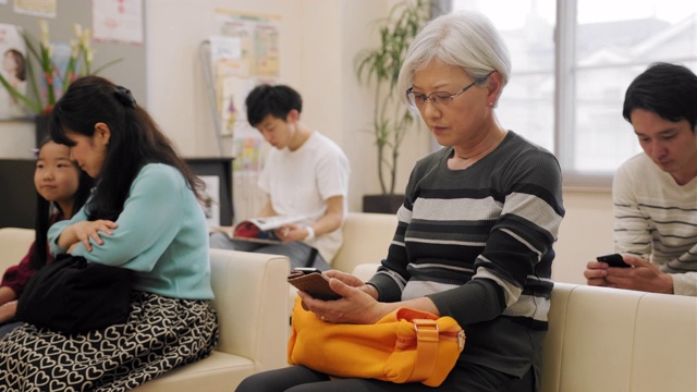 一群不同年龄的日本人在候诊室等待医生视频素材
