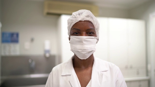 一个成熟的女医生在医院摘下面具微笑的肖像视频素材