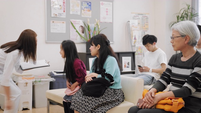 一群不同年龄的日本人在候诊室等待医生视频素材