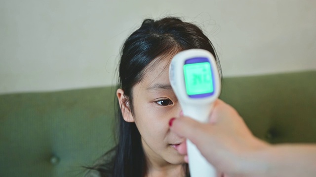 妈妈在家里给女儿测体温。视频下载