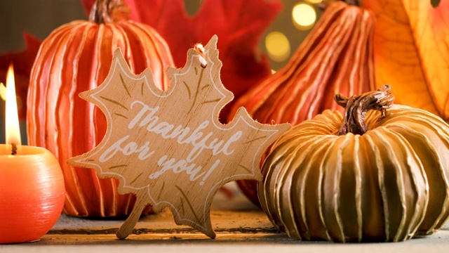 感恩节装饰南瓜和贺卡的照明背景和一个质朴的木制桌子视频下载