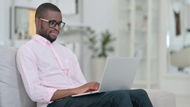 勤劳的非洲年轻人在家里用笔记本电脑工作视频素材