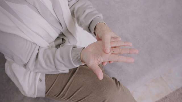 4k视频显示亚洲资深女性手痛。按摩她的手。视频素材