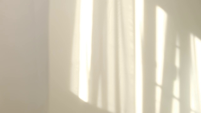 早晨的阳光照亮房间，阴影背景覆盖。在窗边挥动着白色薄纱视频素材