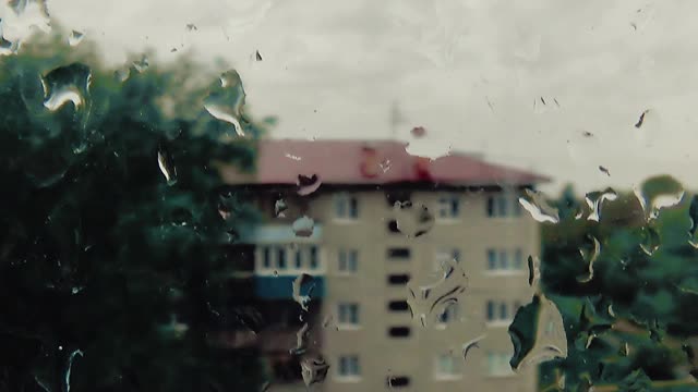 下雨了。水滴从玻璃上滑落。视频素材