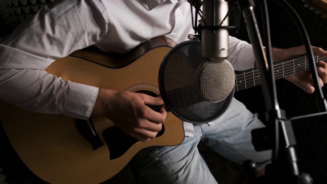 一个年轻的吉他手是在现代录音室录制新歌的特写视频下载