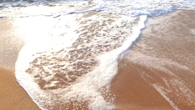 在海滩上发短信，在沙滩上溅起浪花，祝你2021年新年快乐视频素材