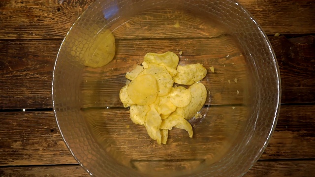 开胃的黄色炸土豆片掉进玻璃碗里视频素材