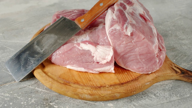 将生猪肉切成片放在砧板上烹调。视频下载