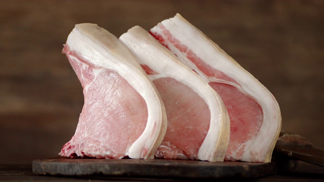 生猪肉肉排在砧板上慢慢旋转。视频下载