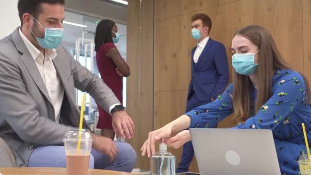 在新冠肺炎大流行期间，同事们戴着防护口罩在午餐时间交谈视频下载