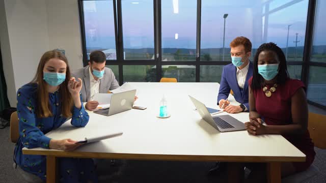 商务人员在会议室开会，戴着防护口罩。视频下载