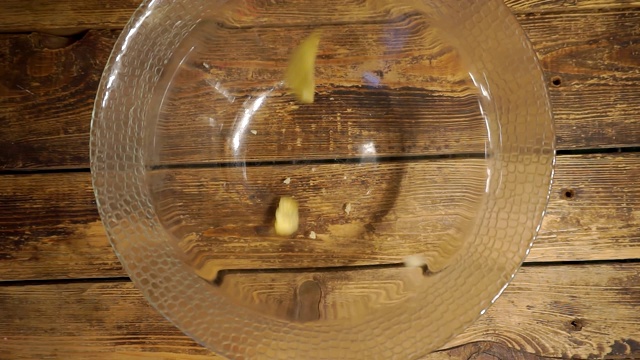 黄色美味的炸土豆片，落在一个玻璃碗里视频素材