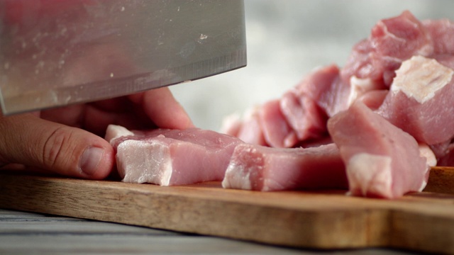 用大刀把生猪肉切成小块。视频下载