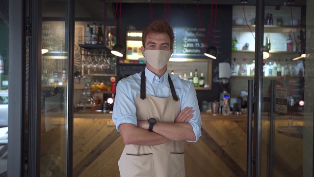 咖啡店员工穿着个人防护服站在咖啡店门前视频下载
