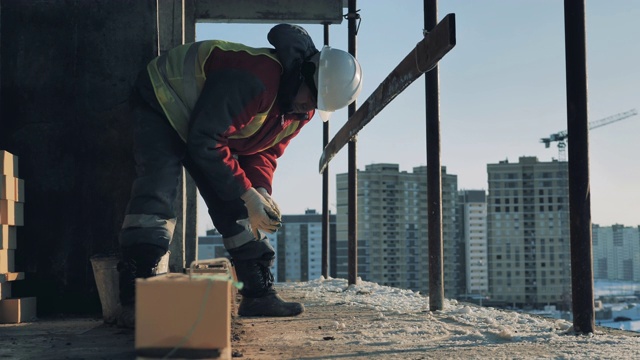 一个工人正在一座在建的多层房子里修理砖视频素材