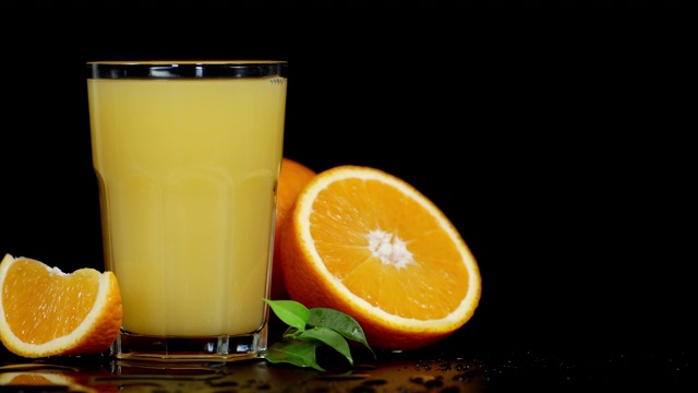 一杯橙汁慢慢地旋转着。视频素材