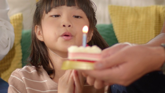 快乐的亚洲妈妈和爸爸给她可爱的小女儿一个惊喜，给他们的孩子一个生日蛋糕。视频素材