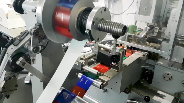 德国一家巧克力工厂用机器打印彩色糖果包装纸。视频下载
