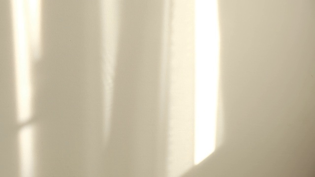 早晨的阳光照亮房间，阴影背景覆盖。在窗边挥动着白色薄纱视频素材