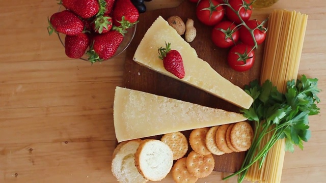 奶酪拼盘与有机奶酪，水果，坚果在一个木制的背景。从以上观点。草莓。美味的奶酪点心。视频下载