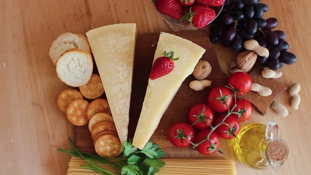 奶酪拼盘与有机奶酪，水果，坚果在一个木制的背景。从以上观点。樱桃。美味的奶酪点心。视频下载