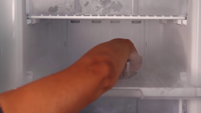 女人手在雾中打开冰箱放入，取出手机视频下载