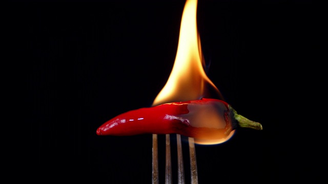叉子上的红辣椒着火了。视频素材