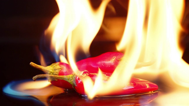 炽热的红辣椒在明亮的火焰中燃烧。视频素材