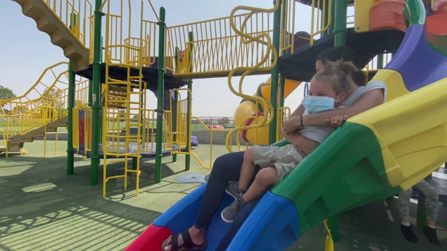 母子戴着口罩在公园里玩耍，以保护自己不受新冠病毒感染视频下载