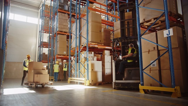 零售仓库堆满货架与货物:电动叉车卡车操作员升降机托盘与纸板盒在货架上。在物流配送中心工作的人，扫描产品，使用卡车视频素材