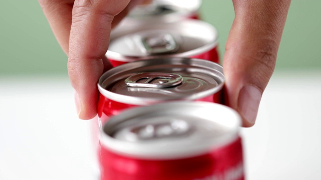 手挑一罐装在红色容器里的软饮料视频下载