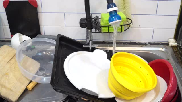 水槽里的脏盘子随着水流流动视频素材