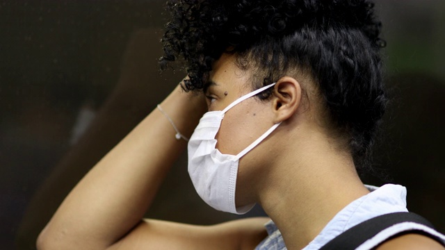 在地铁里通勤的黑人女孩。年轻的千禧一代妇女戴着冠状病毒口罩视频素材
