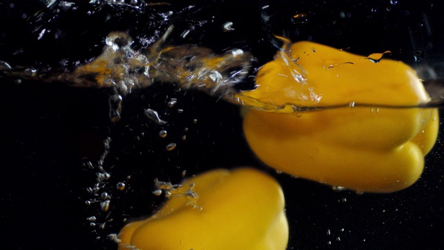 黄色甜椒落入水中溅起水花。视频素材