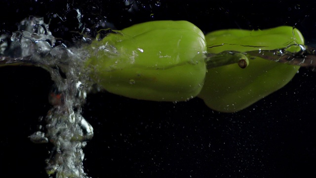 整个甜椒带着气泡落入水中。视频素材