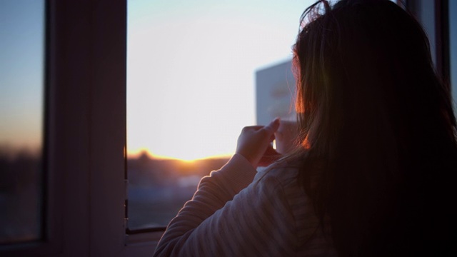 日落时分，在阳台上喝咖啡的女人，视频下载