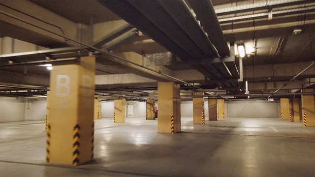 男子驾驶寻找空停车场照明地下停车场下的现代商场与许多车辆视频素材