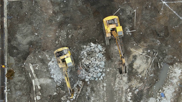 地面上建筑工地的工人和挖掘机的无人机鸟瞰图视频素材